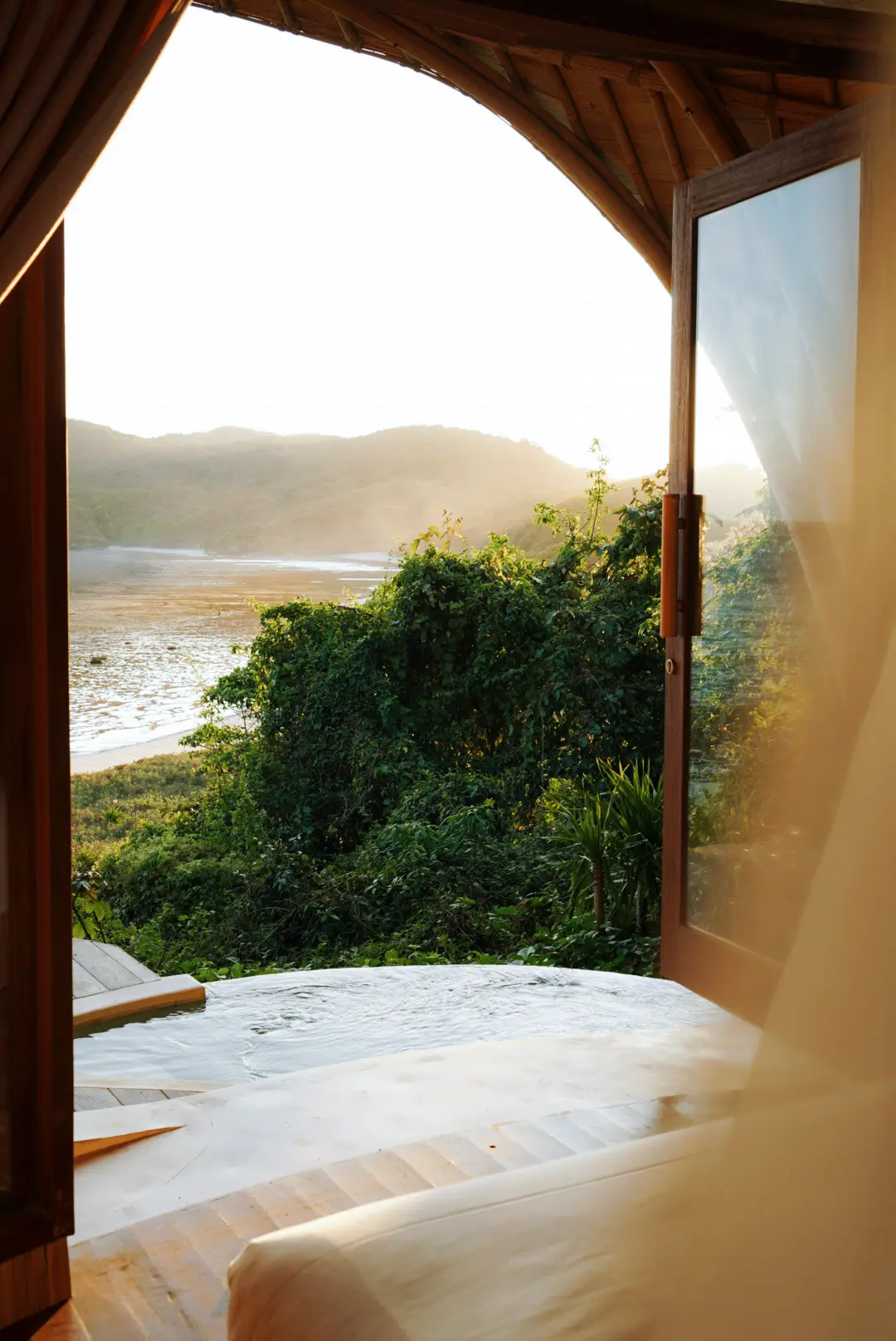 Eco Bamboo Beach Front Lodge exterior surrounded by tropical jungle — handcrafted bamboo architecture at Kini Resort Sumbawa